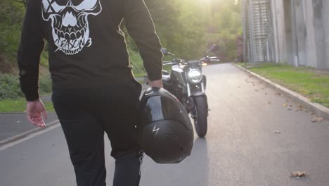 Motorradfahrer-Mit-Helm-In-Der-Hand-Geht-In-Zeitlupe-Zu-Seinem-Motorrad