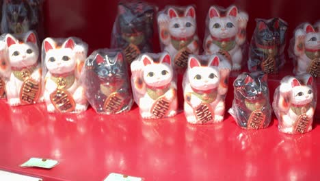 Maneki-cat,-Lucky-cat,-lined-up-outside-of-a-market-in-Kyoto,-Japan-soft-lighting-slow-motion-4K