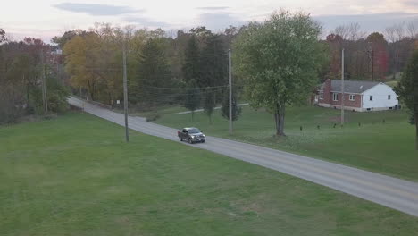 Aerial-tracking-shot-of-cars-on-small-town-road