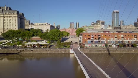 Luftfliegen-Neben-Frauenbrücke-Mit-Libertador-Gebäude-Und-Casa-Rosada-Im-Hintergrund