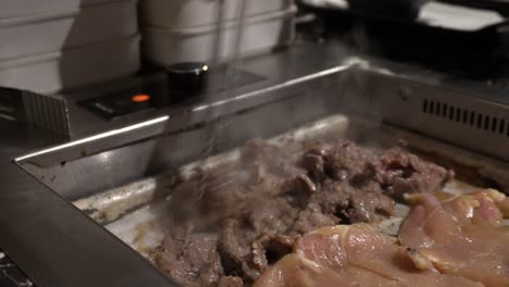 Sie-Können-Sehen,-Wie-Jemand-Das-Rindfleisch-Auf-Einem-Koreanischen-Grill-Dreht