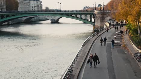Nov-2019,-Paris,-France:-people-walking-along-the-Seine-river-on-a-beautiful-autumn-day