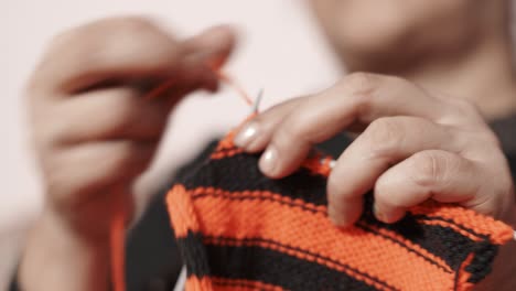 Woman's-hands-doing-knit-work-tie-up-hand-work-with-red-and-black-wool