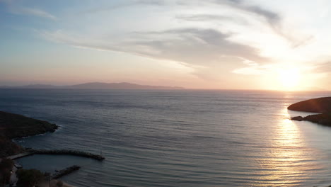 Vista-Aérea-De-Drones-De-La-Hermosa-Puesta-De-Sol-En-Cove-En-Grecia-Con-Vistas-Al-Mar-Egeo