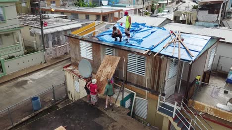 Leute,-Die-Dach-Auf-Haus-Nach-Hurrikanschaden-In-Vororten-Von-San-Juan,-Puerto-Rico,-Luftbild-Befestigen