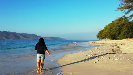 Mujer-Joven-Caminando-Descalza-Por-La-Playa-De-Arena-En-Tailandia