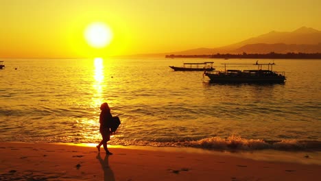 Tropisches-Urlaubskonzept,-Silhouette-Einer-Frau,-Die-Am-Goldenen-Sonnenuntergang-Am-Sandstrand-Spazieren-Geht---Dominikanische-Republik