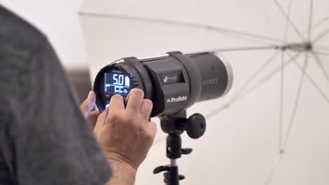 Professional-photographer-calibrating-a-Profoto-flash-head-in-preparation-of-a-photoshoot