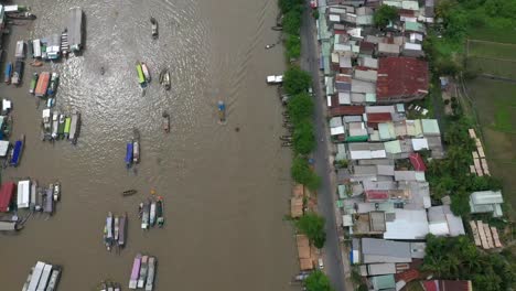 Cai-Rang-floating-market-on-the-Mekong-River,-Vietnam-high-angle-following-the-river-from-drone-during-the-day