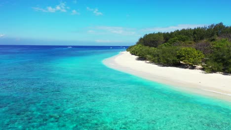 Paradise-white-beach-in-front-of-calm-clear-water-of-blue-azure-sea-lagoon-on-a-bright-sky-with-little-clouds-rising-from-ocean-horizon-in-Seychelles