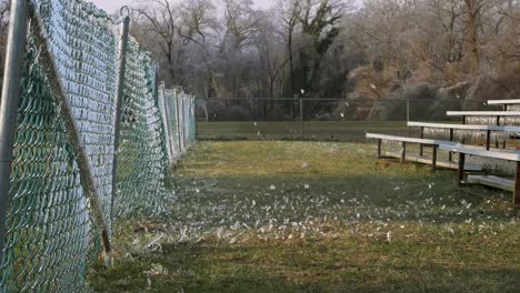 SLOW-MOTION:-A-side-shot-of-a-soccer-ball-slamming-into-an-icy-fence-which-explodes-the-shattered-ice-into-the-air