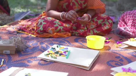 Arme-Indische-Frauen,-Die-Taschen-Herstellen-Und-Sie-Mit-Buntem-Papierhandwerk-Im-Freien-Dekorieren