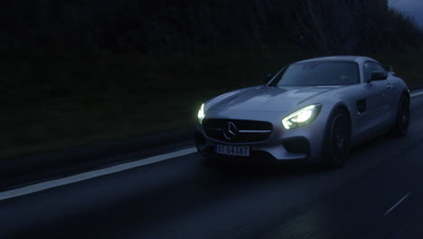 Mercedes-Benz-Sports-Travelling-On-The-Highway-Of-Nannestad,-Norway-In-The-Evening---Wide-Moving-Shot