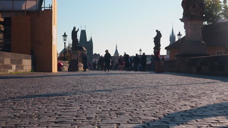 Tourists-walking-in-paved-central-square-with-statues-in-Prague-Czech-Republic
