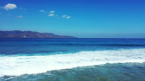 Foamy-waves-of-turquoise-ocean-waters-rolling-on-the-sandy-coast