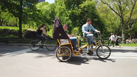 Cycling-and-rickshaw-riding-in-Central-Park-in-New-York-City,-modern-urban-transportation-and-exploration-of-Manhattan