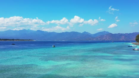 Paradiesische-Tropische-Bucht-Mit-Flacher-Blauer-Azurblauer-Lagune,-In-Der-Viele-Boote-Um-Die-Tropische-Insel-Voller-Resorts-Für-Den-Urlaub-In-Indonesien-Segeln-Und-Schwimmen