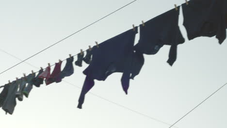 Hand-held-shot-of-full-clothelines-withlaundry-against-the-sun-in-Hangberg-township-in-Hout-Bay,-South-Africa