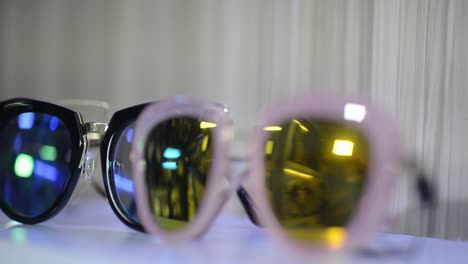 Sunglasses-for-sale-in-shop-storefront,-closeup-rack-focus