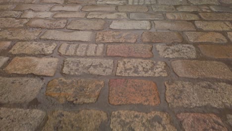 Wet-cobblestone-road-after-rain,-Closeup-Moving-Forward
