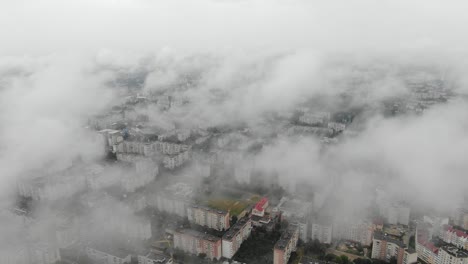 Luftaufnahme-Des-Stadtbildes-Durch-Wolken,-Die-Langsam-Absteigen