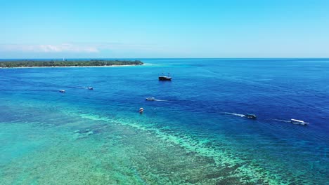 Vivid-colors-of-panoramic-view-of-boats-sailing-on-deep-blue-sea-and-turquoise-lagoon-with-coral-reefs-on-shore-of-tropical-islands-in-Bali