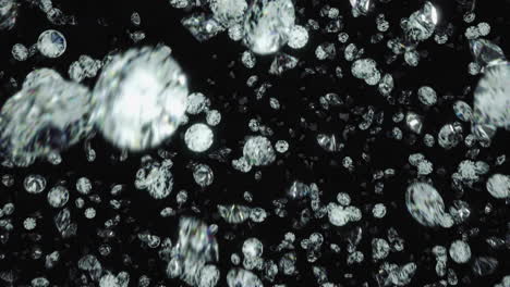 Diamonds-rotating-and-falling-towards-camera-lens-against-black-background-in-slow-motion