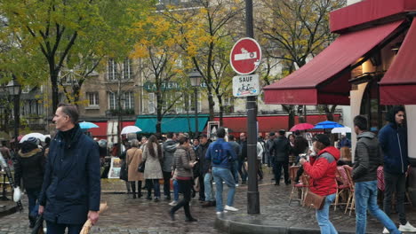 Nov-2019,-Paris,-France:-Place-Du-Tertre,-in-Montmartre-district-of-Paris-crowded-with-tourists-walking-between-cafes-and-restaurants-in-a-grey-Autumn-morning