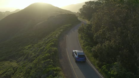 Blue-Porsche-Macan-on-a-coastal-ocean-view-in-the-Marin-Headlands,-San-Fransisco,-at-golden-hour