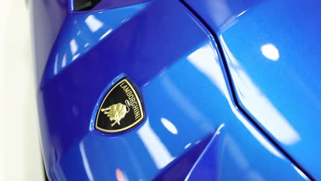 Yellow-Lamborghini-badge-on-blue-supercar