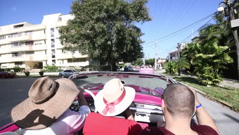 Drei-Freunde,-Die-Ein-Altmodisches-Traditionelles-Auto-Cabrio-Um-Die-Straße-Von-Havanna-Fahren