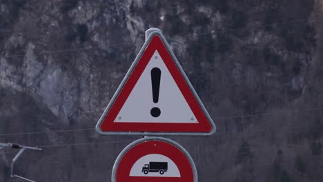 Blinking-warning-sign-representing-exclamation-mark-in-white-triangle,-on-road-side