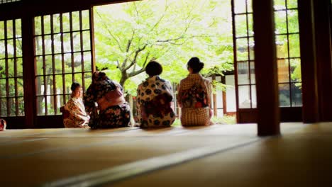 Frauen,-Die-Einen-Kimono-Tragen,-Sitzen-Am-Fenster-Eines-Traditionellen-Japanischen-Hauses-Im-Samurai-stil,-Ryokan-In-Kyoto