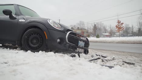 Crashed-mini-cooper-on-the-side-of-the-road-in-snow