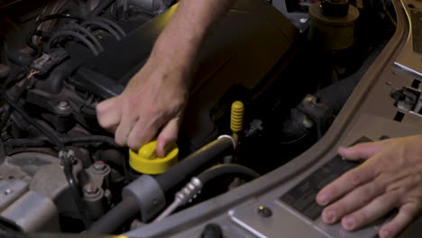 Removing-the-engine-oil-cap-to-add-more-oil