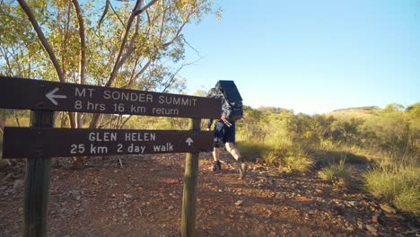 Hiker-walks-past-sign-on-Larapinta-Trail,-Central-Australia