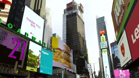 Tilt-Down-From-Advertising-Signage-To-A-Nearly-Empty-Times-Square,-New-York-City,-During-The-Coronavirus-Crisis