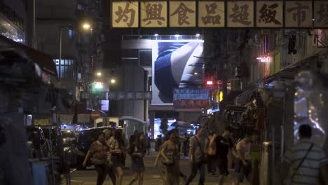 Eine-Provokative-Werbung-Ist-Auf-Der-Straße-Zu-Sehen,-Im-Hintergrund-Hängt-Sie-An-Der-Fassade-Eines-Einkaufszentrums-Im-Bezirk-Kowloon,-Hong-Kong