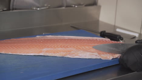 Close-Up-Shot-of-a-Chef-the-Cleaning,-Preparation-and-Slicing-a-Fresh-Salmon-Fillet