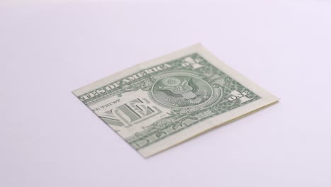 Un-Dólar-Gire-Sobre-Fondo-Blanco-En-El-Estudio-Fotográfico