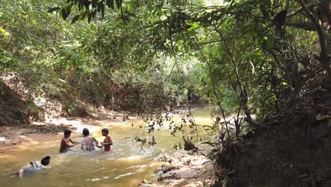 Niños-Jugando-En-El-Río-Rodeados-De-árboles