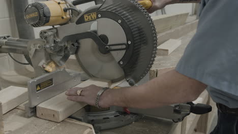 Carpenter-uses-a-mitre-saw-table-saw-to-cut-a-2x4-piece-of-wood