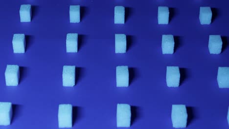 4K-Neigungsansicht-Eines-Einzigartigen-Kubischen-Hintergrunds-Mit-Weißen-Zuckerwürfeln,-Die-In-Reihen-Auf-Einem-Dunkelblauen-Hintergrund-Angeordnet-Sind,-3D-Effekt