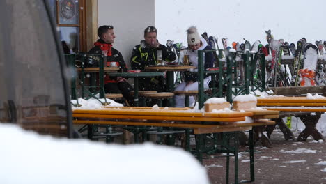 Friends-chatting-at-ski-resort-bar-during-snowfall