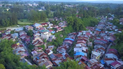 Scenic-fly-over-a-poor-friendly-neigbourhood-rooftop-surrounded-by-beautiful-trees-and-natural-green-park-in-a-suburb-of-Indonesia