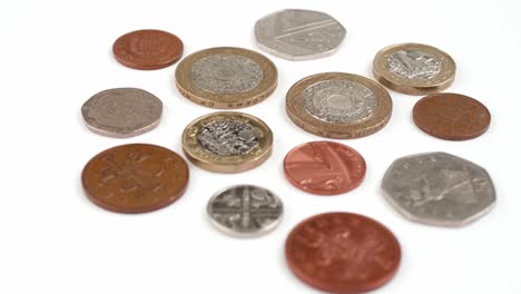 Moneda-Británica-Libras-Monedas-Girando-Imágenes-De-Cerca-Contra-El-Fondo-Blanco