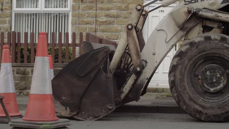 Heavy-plant-digger-and-road-cones-parked-in-street