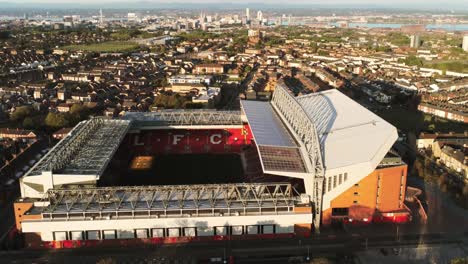 Iconic-Liverpool-Anfield-football-stadium-ground-at-sunrise-aerial-view-rising-tilt-down