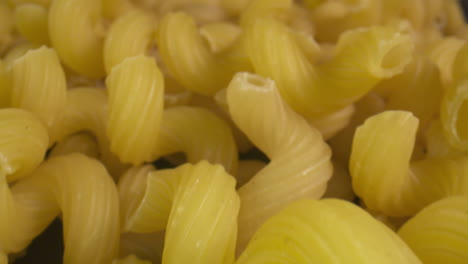 Macro-slide-across-a-pile-of-dry-tortiglioni-pasta