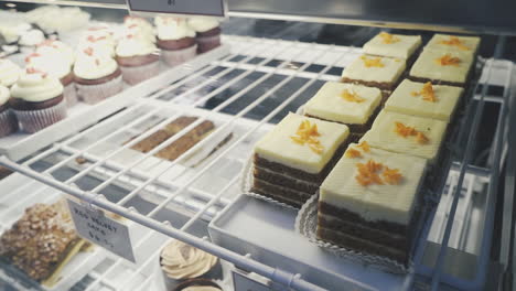 Delicious-squares-of-carrot-cake-and-red-velvet-cupcakes-in-a-bakery-display